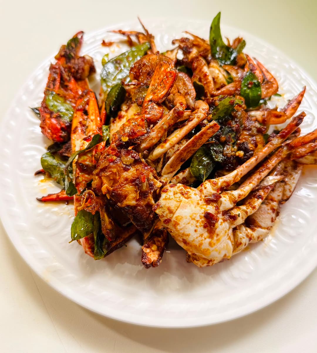 Jaffna crab curry on a white plate.