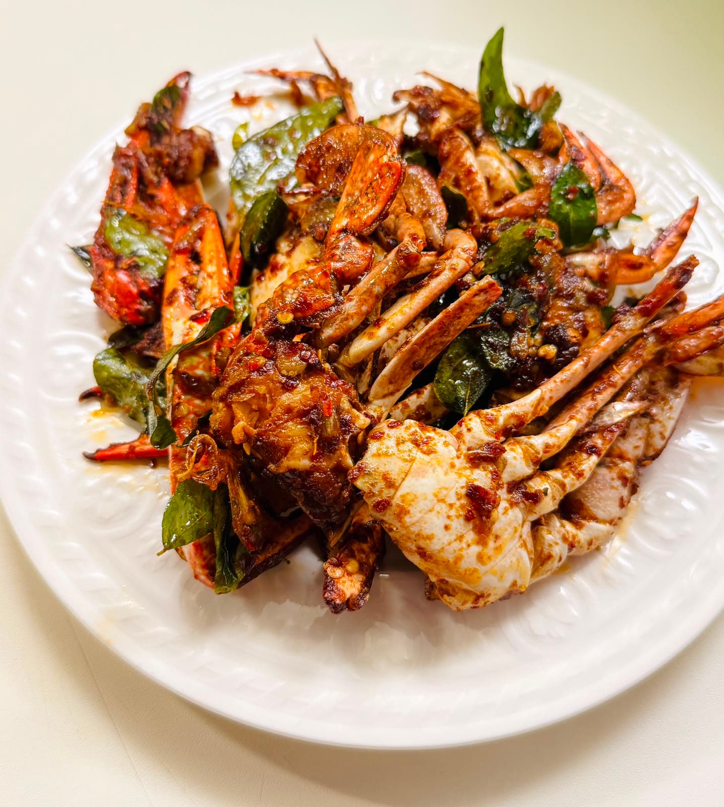 Jaffna crab curry served on a white plate.